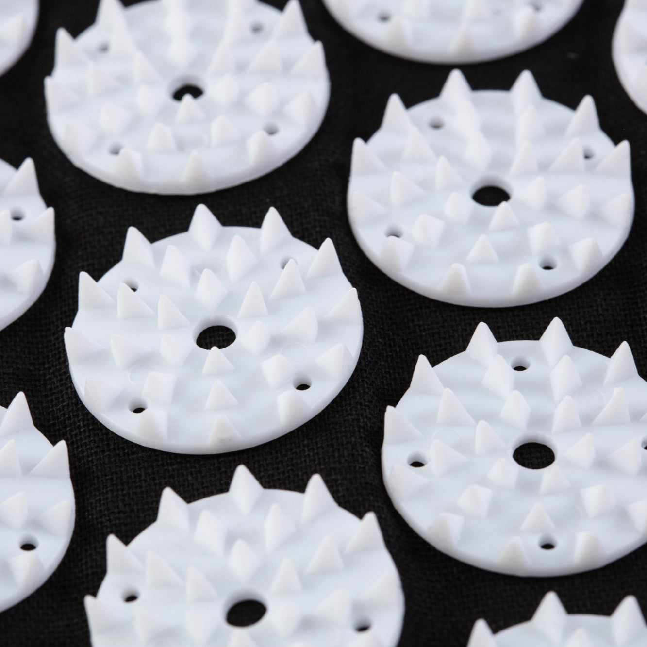 White circular objects with spike-like protrusions on a black background