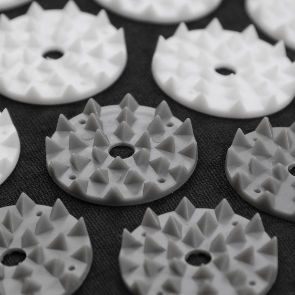 White plastic components with textured surface on a black background