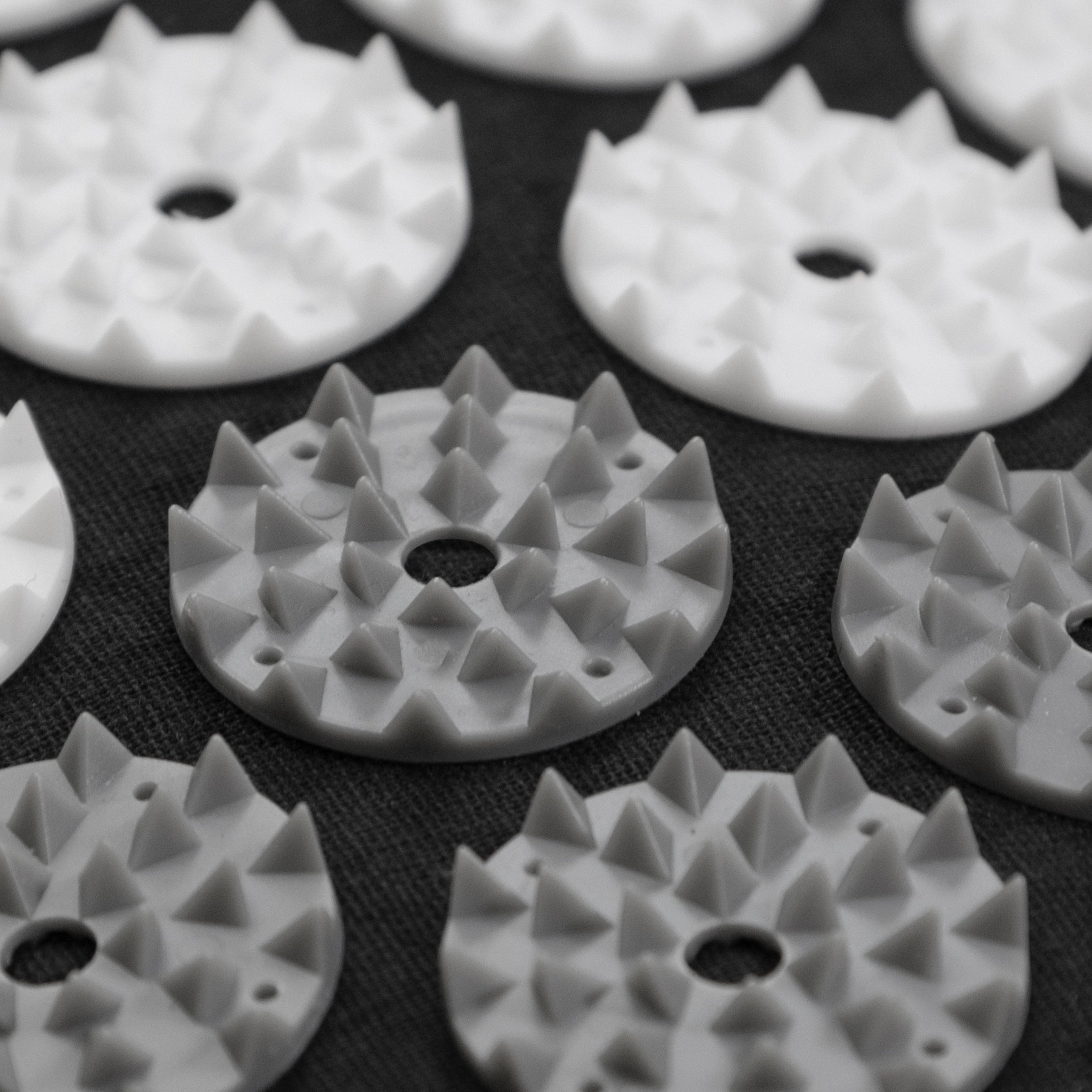 White plastic components with textured surface on a black background