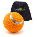 Orange massage ball with a silver handle next to a black drawstring bag labeled 'Lyfe Focus' on a white background.