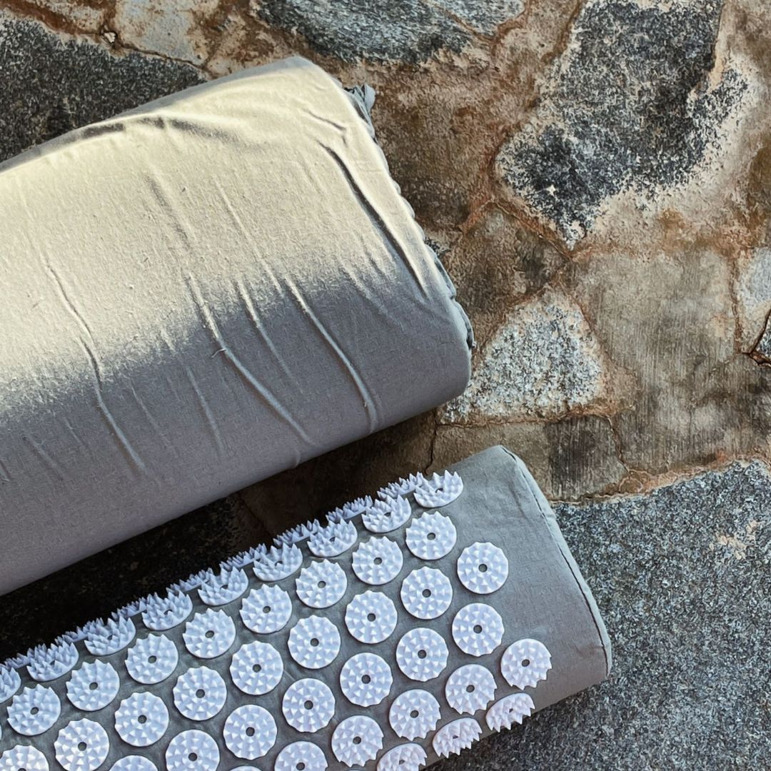 Roll of gray fabric with textured surface on a stone surface