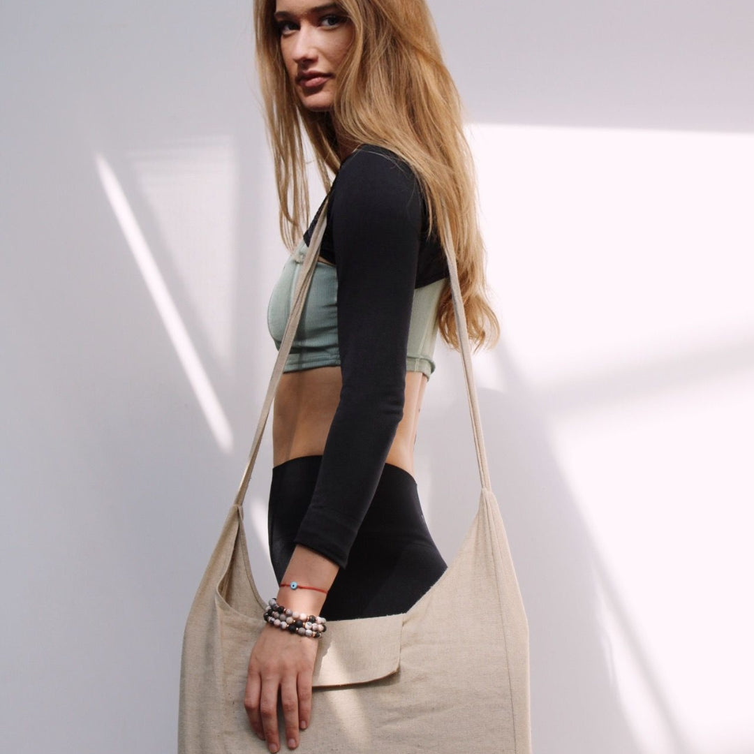 Woman holding a beige tote bag against a white background